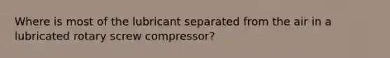 Where is most of the lubricant separated from the air in a lubricated rotary screw compressor?