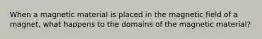 When a magnetic material is placed in the magnetic field of a magnet, what happens to the domains of the magnetic material?