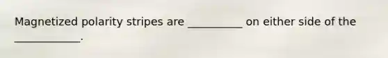 Magnetized polarity stripes are __________ on either side of the ____________.