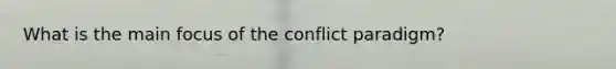 What is the main focus of the conflict paradigm?