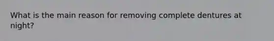 What is the main reason for removing complete dentures at night?