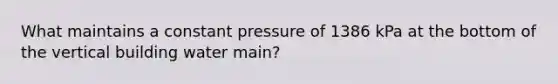 What maintains a constant pressure of 1386 kPa at the bottom of the vertical building water main?