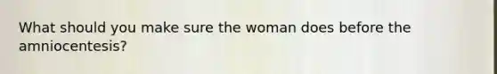What should you make sure the woman does before the amniocentesis?