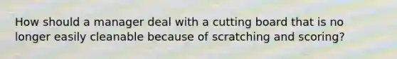 How should a manager deal with a cutting board that is no longer easily cleanable because of scratching and scoring?