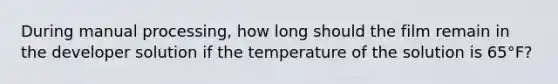 During manual processing, how long should the film remain in the developer solution if the temperature of the solution is 65°F?