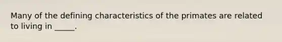 Many of the defining characteristics of the primates are related to living in _____.