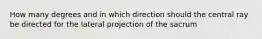 How many degrees and in which direction should the central ray be directed for the lateral projection of the sacrum