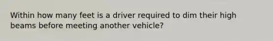 Within how many feet is a driver required to dim their high beams before meeting another vehicle?