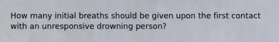 How many initial breaths should be given upon the first contact with an unresponsive drowning person?