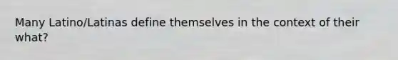Many Latino/Latinas define themselves in the context of their what?