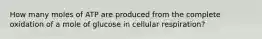 How many moles of ATP are produced from the complete oxidation of a mole of glucose in cellular respiration?