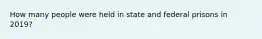 How many people were held in state and federal prisons in 2019?