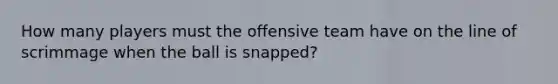 How many players must the offensive team have on the line of scrimmage when the ball is snapped?