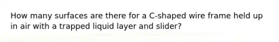 How many surfaces are there for a C-shaped wire frame held up in air with a trapped liquid layer and slider?