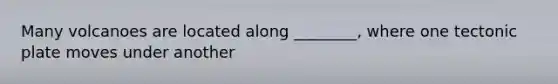 Many volcanoes are located along ________, where one tectonic plate moves under another