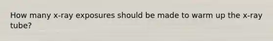 How many x-ray exposures should be made to warm up the x-ray tube?