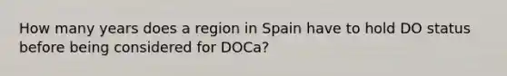 How many years does a region in Spain have to hold DO status before being considered for DOCa?