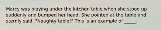 Marcy was playing under the kitchen table when she stood up suddenly and bumped her head. She pointed at the table and sternly said, "Naughty table!" This is an example of _____.