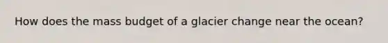 How does the mass budget of a glacier change near the ocean?