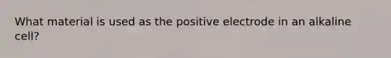 What material is used as the positive electrode in an alkaline cell?