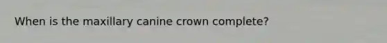 When is the maxillary canine crown complete?