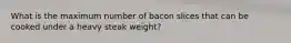 What is the maximum number of bacon slices that can be cooked under a heavy steak weight?