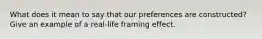 What does it mean to say that our preferences are constructed? Give an example of a real-life framing effect.