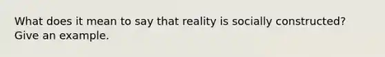 What does it mean to say that reality is socially constructed? Give an example.