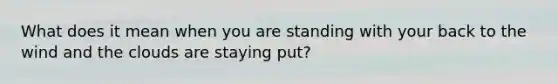 What does it mean when you are standing with your back to the wind and the clouds are staying put?