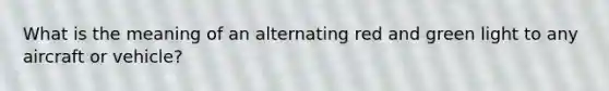What is the meaning of an alternating red and green light to any aircraft or vehicle?