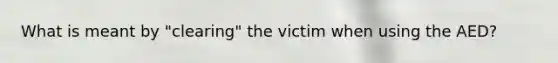 What is meant by "clearing" the victim when using the AED?