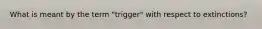 What is meant by the term "trigger" with respect to extinctions?