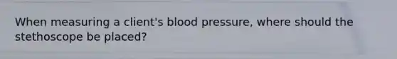 When measuring a client's blood pressure, where should the stethoscope be placed?