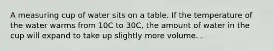 A measuring cup of water sits on a table. If the temperature of the water warms from 10C to 30C, the amount of water in the cup will expand to take up slightly more volume. .