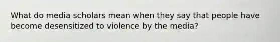 What do media scholars mean when they say that people have become desensitized to violence by the media?