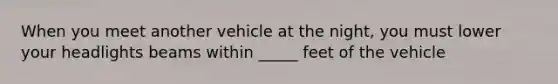 When you meet another vehicle at the night, you must lower your headlights beams within _____ feet of the vehicle