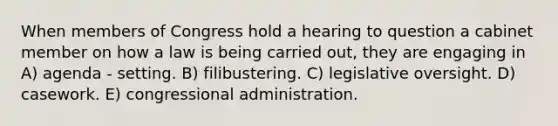 When members of Congress hold a hearing to question a cabinet member on how a law is being carried out, they are engaging in A) agenda - setting. B) filibustering. C) legislative oversight. D) casework. E) congressional administration.