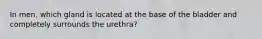 In men, which gland is located at the base of the bladder and completely surrounds the urethra?