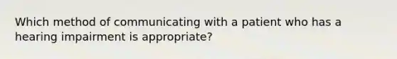 Which method of communicating with a patient who has a hearing impairment is appropriate?