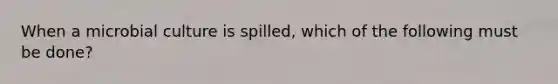 When a microbial culture is spilled, which of the following must be done?