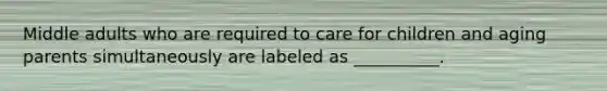 Middle adults who are required to care for children and aging parents simultaneously are labeled as __________.