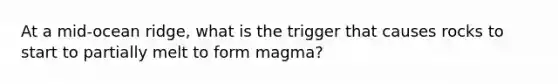 At a mid-ocean ridge, what is the trigger that causes rocks to start to partially melt to form magma?