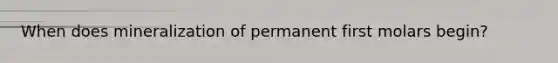 When does mineralization of permanent first molars begin?