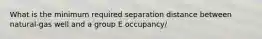 What is the minimum required separation distance between natural-gas well and a group E occupancy/