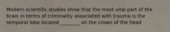 Modern scientific studies show that the most vital part of the brain in terms of criminality associated with trauma is the temporal lobe located ________ on the crown of the head