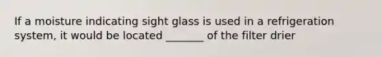 If a moisture indicating sight glass is used in a refrigeration system, it would be located _______ of the filter drier