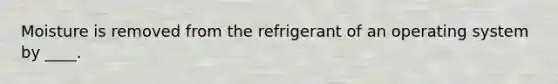 Moisture is removed from the refrigerant of an operating system by ____.