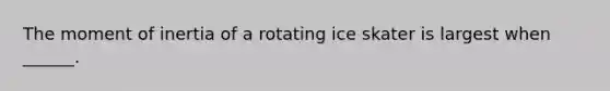 The moment of inertia of a rotating ice skater is largest when ______.