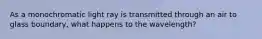 As a monochromatic light ray is transmitted through an air to glass boundary, what happens to the wavelength?