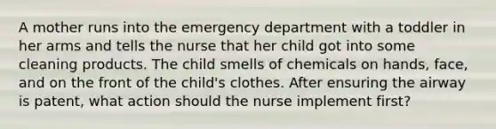 A mother runs into the emergency department with a toddler in her arms and tells the nurse that her child got into some cleaning products. The child smells of chemicals on hands, face, and on the front of the child's clothes. After ensuring the airway is patent, what action should the nurse implement first?